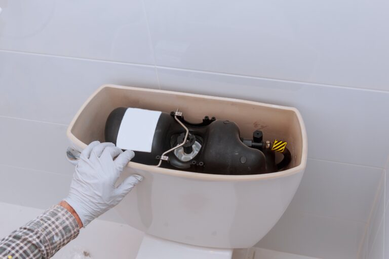 Affordable Plumbing / Plumber repairing toilet tank in bathroom plumbing at home changes the toilet